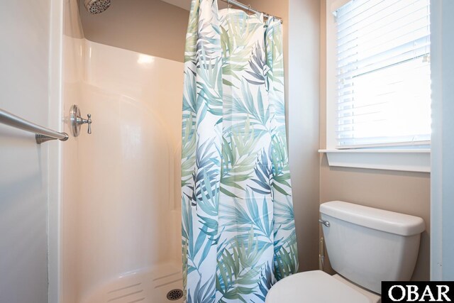 full bathroom featuring a stall shower and toilet