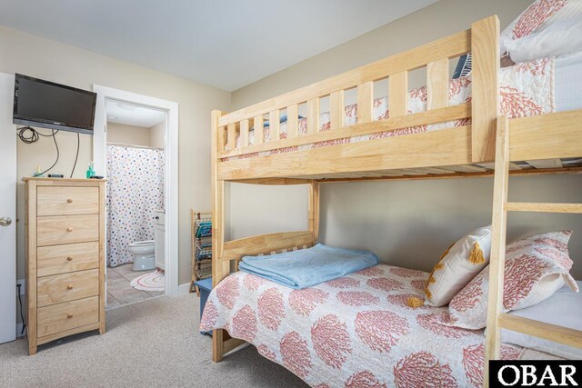 bedroom featuring connected bathroom and carpet flooring