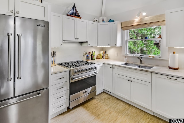 1127 Brumsey Ct Lot 324, Corolla, NC 27927 - kitchen with premium appliances, white cabinets, light stone counters, tasteful backsplash, and vaulted ceiling