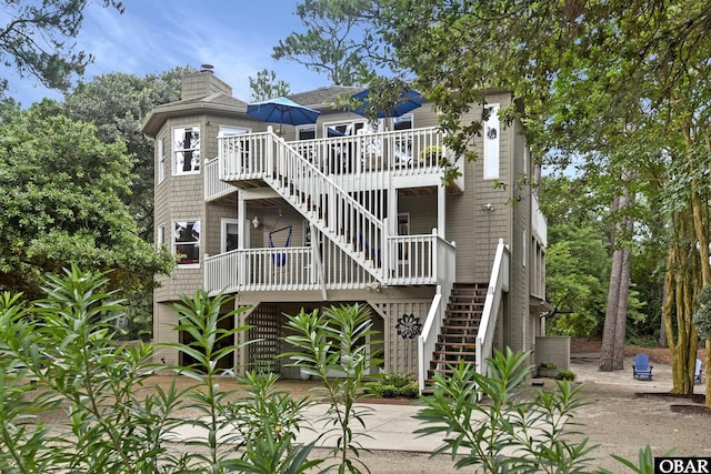 1127 Brumsey Ct Lot 324, Corolla, NC 27927 - back of property with stairway, a wooden deck, and a chimney