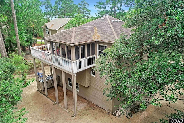 1127 Brumsey Ct Lot 324, Corolla, NC 27927 - rear view of house featuring roof with shingles, a wooden deck, and a sunroom
