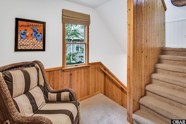 1127 Brumsey Ct Lot 324, Corolla, NC 27927 - living area featuring a wainscoted wall, wood walls, carpet floors, stairs, and vaulted ceiling