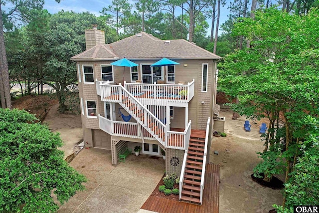 1127 Brumsey Ct Lot 324, Corolla, NC 27927 - view of front of property featuring stairway, an attached garage, concrete driveway, a chimney, and roof with shingles
