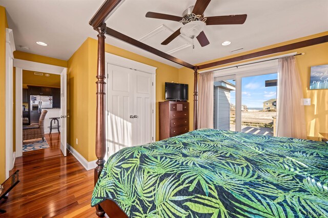 bedroom featuring baseboards, a ceiling fan, stainless steel fridge with ice dispenser, wood finished floors, and access to exterior