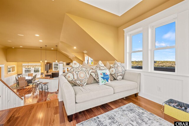 living area featuring vaulted ceiling, wainscoting, wood finished floors, and recessed lighting