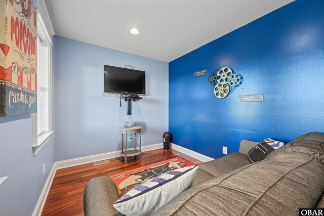 living room featuring visible vents, baseboards, and wood finished floors