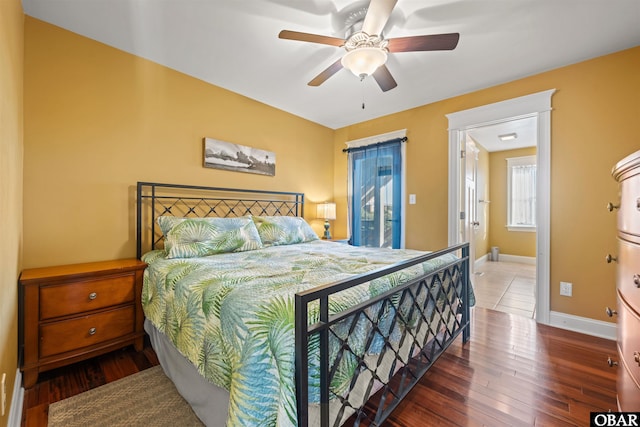 bedroom featuring ceiling fan, wood finished floors, and baseboards