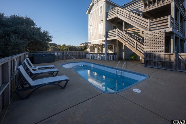 view of swimming pool with a patio area, a hot tub, and outdoor dry bar