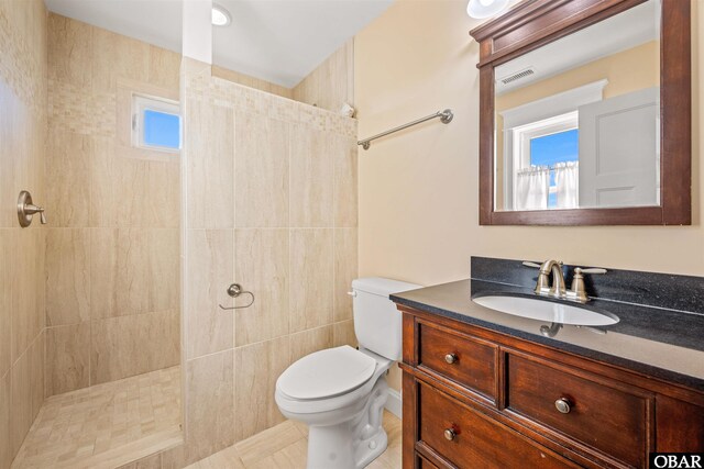 bathroom featuring toilet, visible vents, walk in shower, and vanity