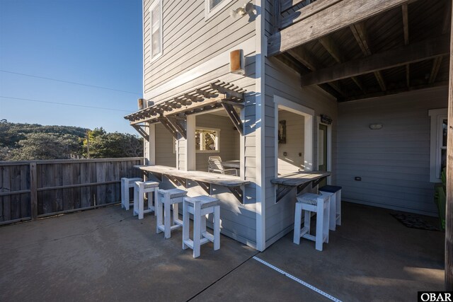 view of patio with fence and outdoor dry bar