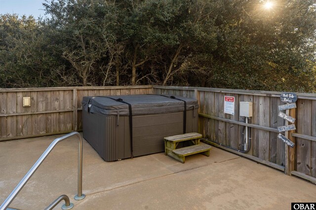 view of patio / terrace featuring a hot tub and fence