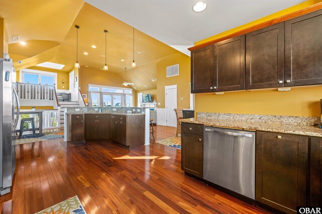 kitchen featuring dark brown cabinetry, visible vents, appliances with stainless steel finishes, light stone countertops, and pendant lighting