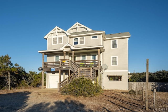 view of front facade with a garage, fence, stairway, and a porch