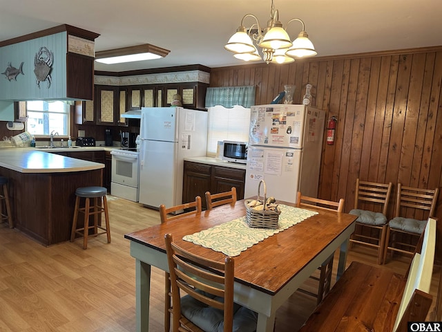 1232 S Virginia Dare Trl Lot 6, Kill Devil Hills, NC 27948 - dining area with a chandelier, crown molding, light wood-style flooring, and wood walls