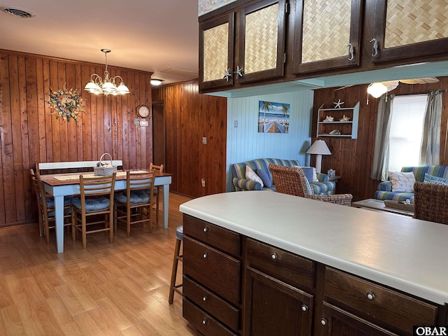 1232 S Virginia Dare Trl Lot 6, Kill Devil Hills, NC 27948 - kitchen featuring wooden walls, light wood-style flooring, glass insert cabinets, hanging light fixtures, and dark brown cabinetry