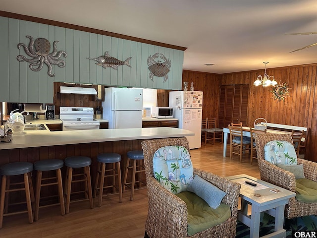 1232 S Virginia Dare Trl Lot 6, Kill Devil Hills, NC 27948 - kitchen with white appliances, under cabinet range hood, wood walls, wood finished floors, and a peninsula