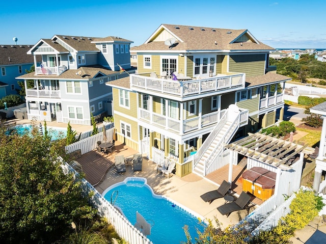 back of house with a fenced in pool, stairway, a patio area, a balcony, and a fenced backyard