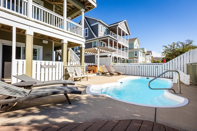 view of swimming pool featuring a fenced in pool, a patio area, fence, a pergola, and a residential view