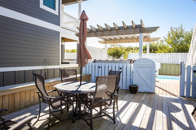 wooden terrace with outdoor dining space, fence, a swimming pool, and a pergola