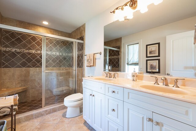 bathroom with double vanity, a stall shower, and a sink