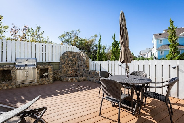 wooden terrace with outdoor dining space, grilling area, and area for grilling