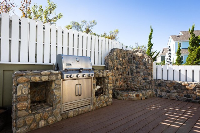 wooden deck with grilling area and an outdoor kitchen