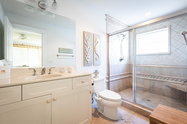 bathroom with tile patterned floors, a stall shower, a wealth of natural light, and vanity