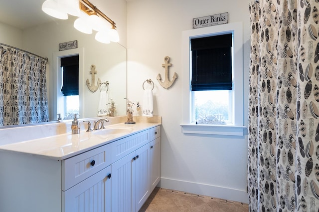 bathroom with curtained shower, tile patterned flooring, vanity, and baseboards