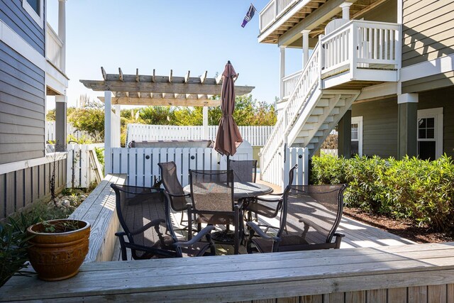 exterior space featuring stairs, outdoor dining area, a deck, and a pergola