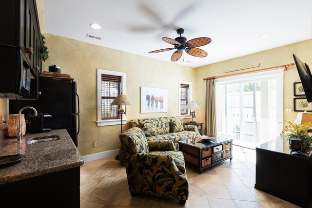 living room featuring visible vents, ceiling fan, baseboards, and light tile patterned floors