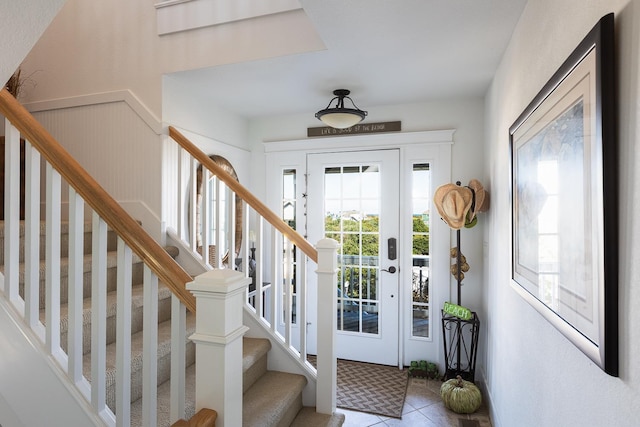 entrance foyer with a wainscoted wall and stairway