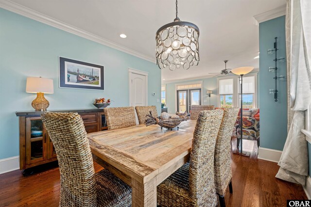 dining room featuring crown molding, baseboards, and wood finished floors