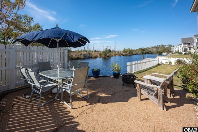 view of patio / terrace featuring a fire pit, a fenced backyard, and a water view