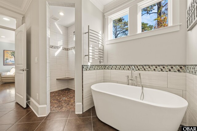 bathroom with tile patterned floors, a freestanding tub, radiator, and ornamental molding