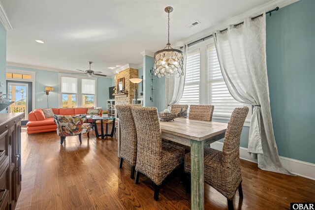 dining area with visible vents, ornamental molding, a ceiling fan, wood finished floors, and baseboards