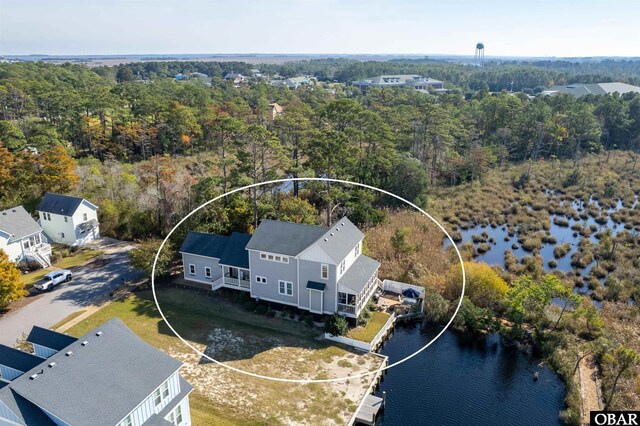 drone / aerial view featuring a water view and a wooded view