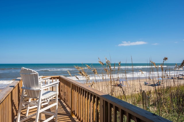 view of property's community featuring a water view and a beach view