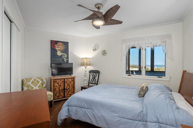 bedroom with ceiling fan, dark wood-type flooring, a closet, and crown molding