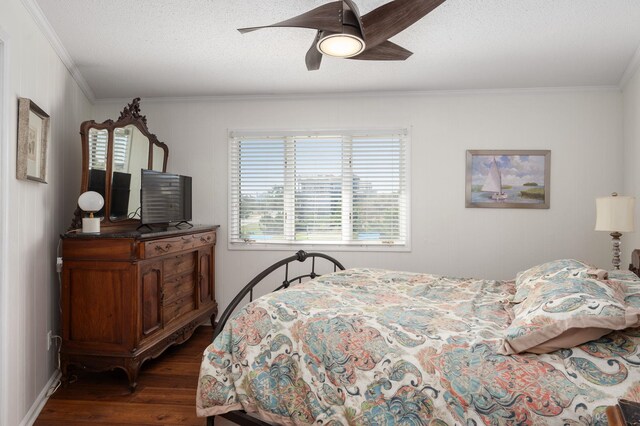 bedroom with crown molding, dark wood finished floors, and a textured ceiling