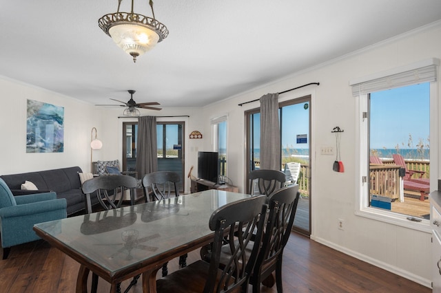 dining space featuring ceiling fan, ornamental molding, dark wood finished floors, and baseboards