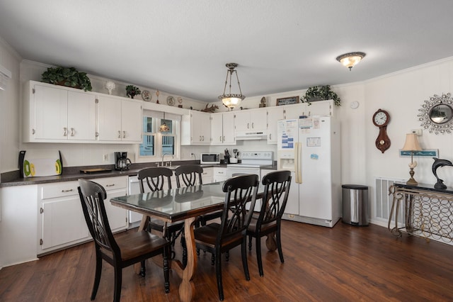 dining room with visible vents, ornamental molding, and dark wood-style flooring