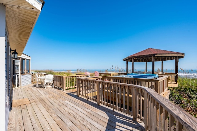 deck featuring a water view, a swimming pool, and a gazebo