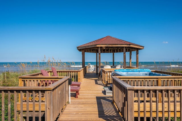 exterior space with a view of the beach, a water view, and a gazebo