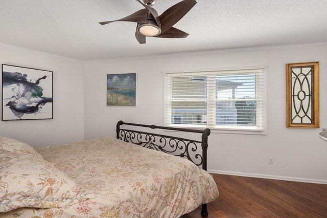 bedroom with dark wood-type flooring, ornamental molding, a ceiling fan, a textured ceiling, and baseboards