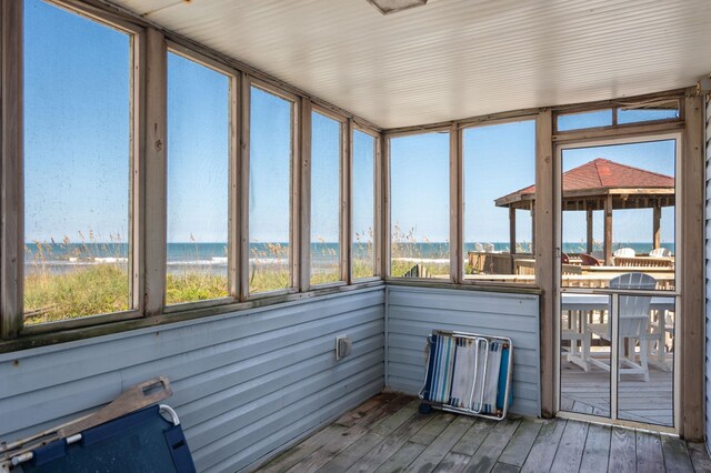 unfurnished sunroom featuring a water view and a wealth of natural light