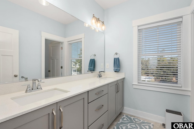 bathroom with plenty of natural light, a sink, and baseboards