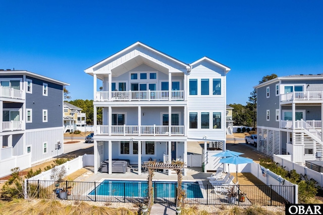 rear view of house with a patio area, a fenced backyard, a fenced in pool, and a jacuzzi