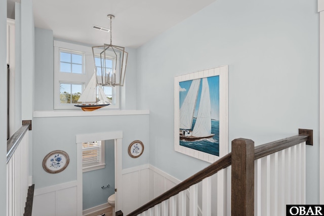 interior space with a chandelier, wainscoting, and visible vents