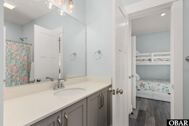 bathroom featuring a shower with shower curtain, wood finished floors, and vanity