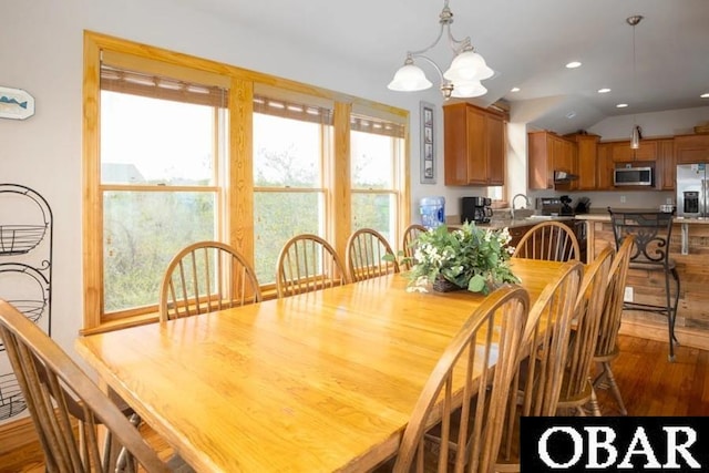 dining room featuring lofted ceiling, recessed lighting, wood finished floors, and a chandelier